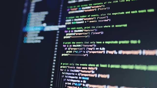 Application source code displayed on a dark monitor